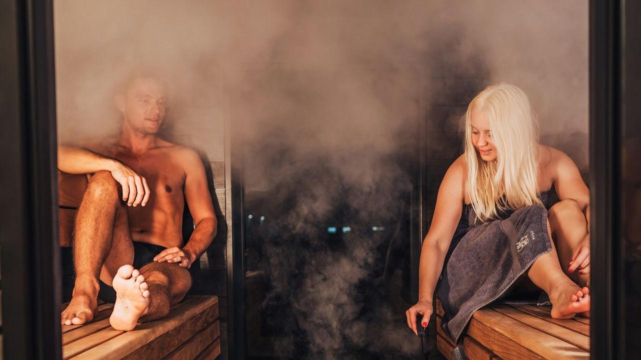 A couple of people that are sitting in a sauna