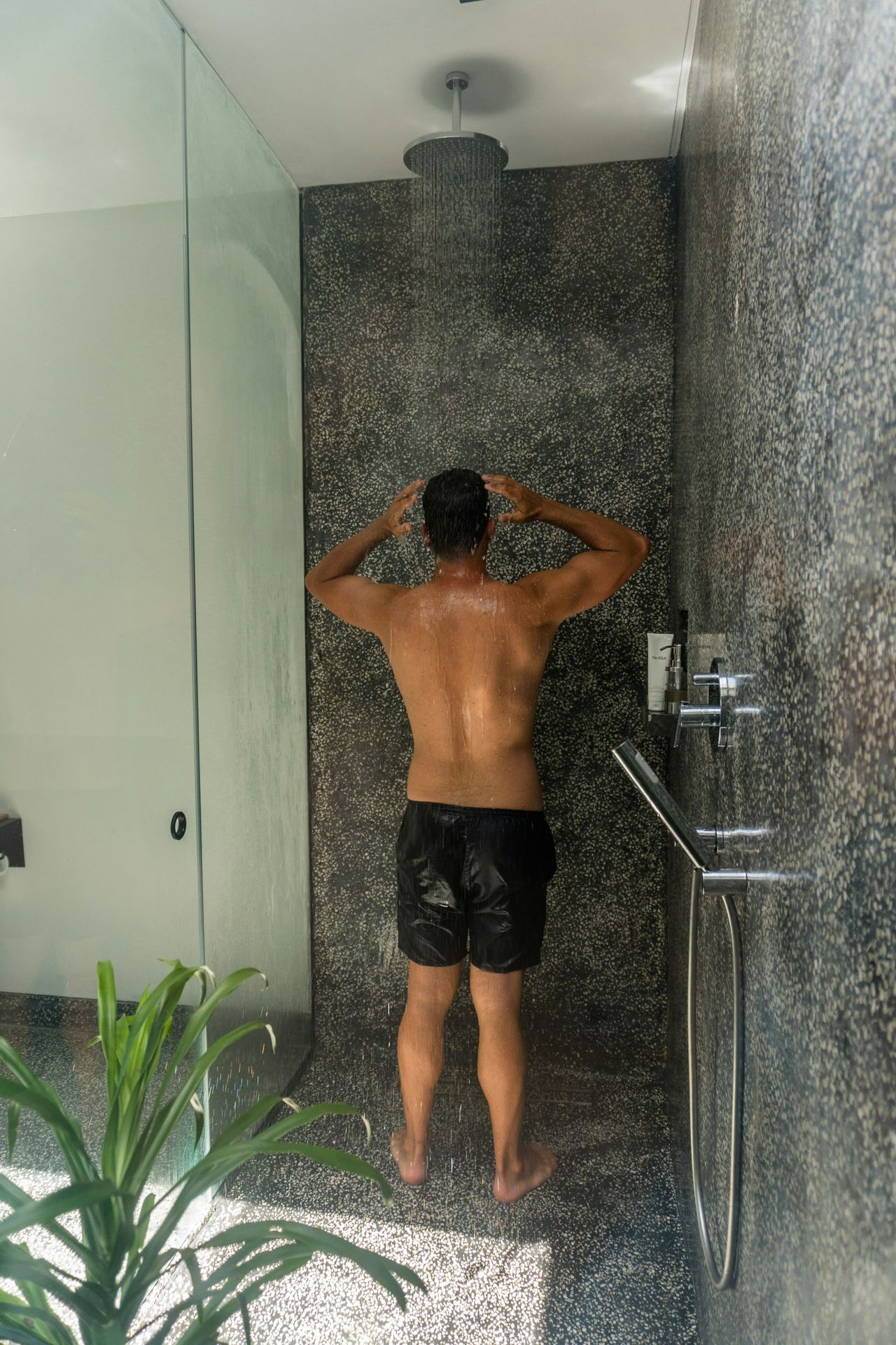 A man standing in front of a shower in a bathroom